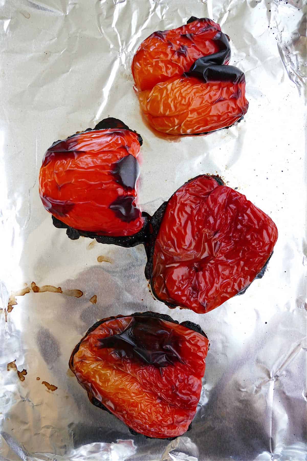 roasted red peppers on a baking sheet lined with aluminum foil