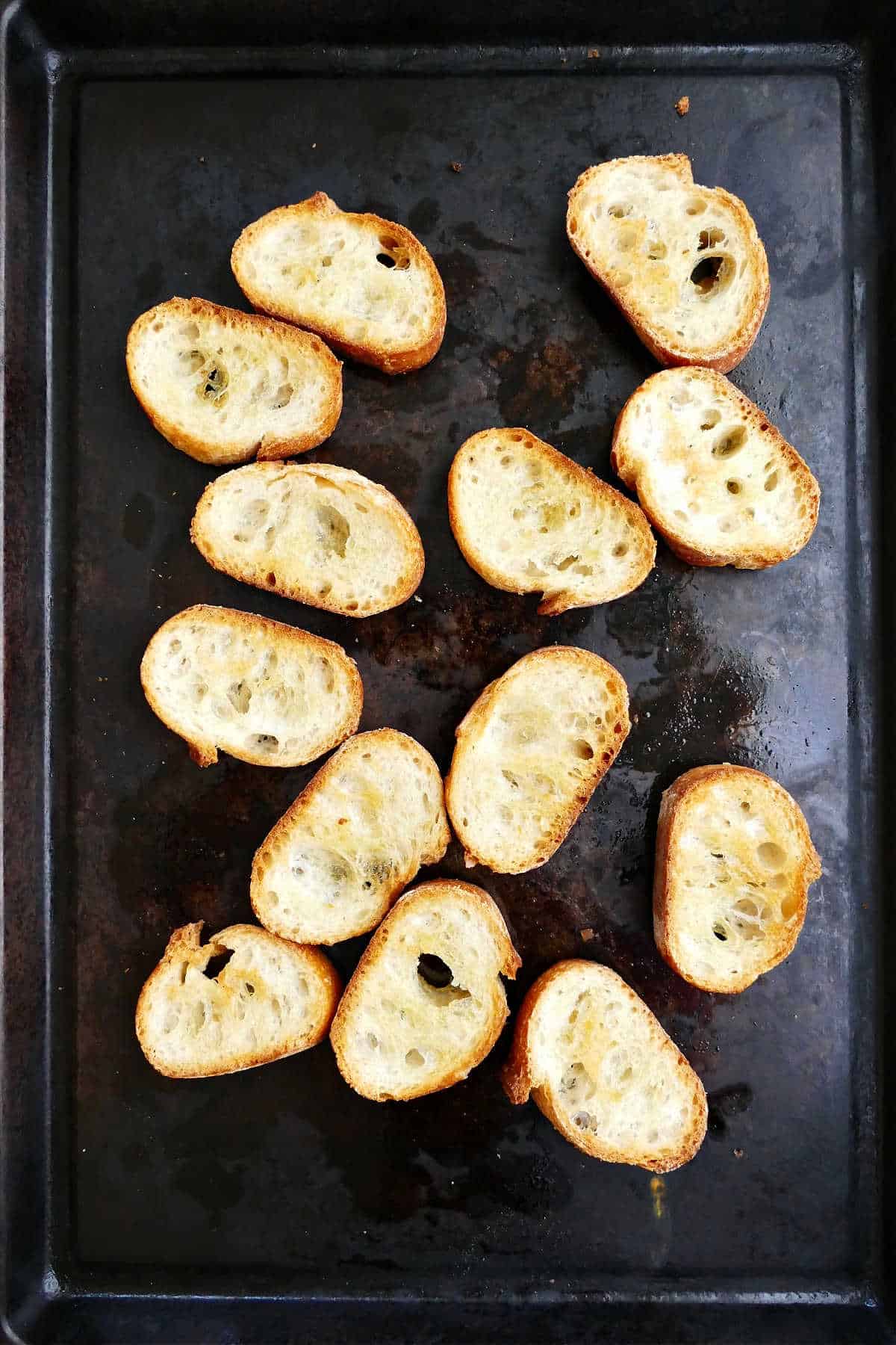 baguette slices spread with oil and toasted on a baking sheet