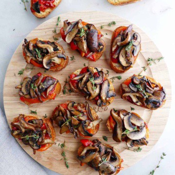 bruschetta with mushrooms and roasted peppers on a circular serving tray