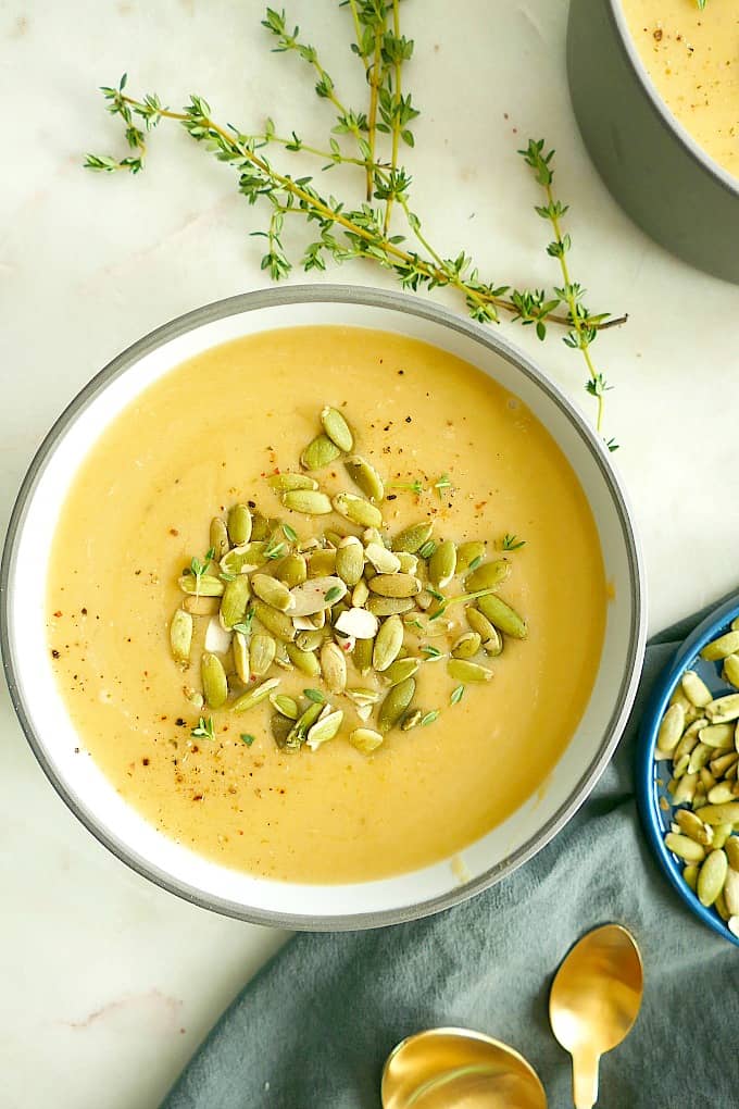 bowl of vegan Butternut Squash and Pear Soup topped with pumpkin seeds and thyme