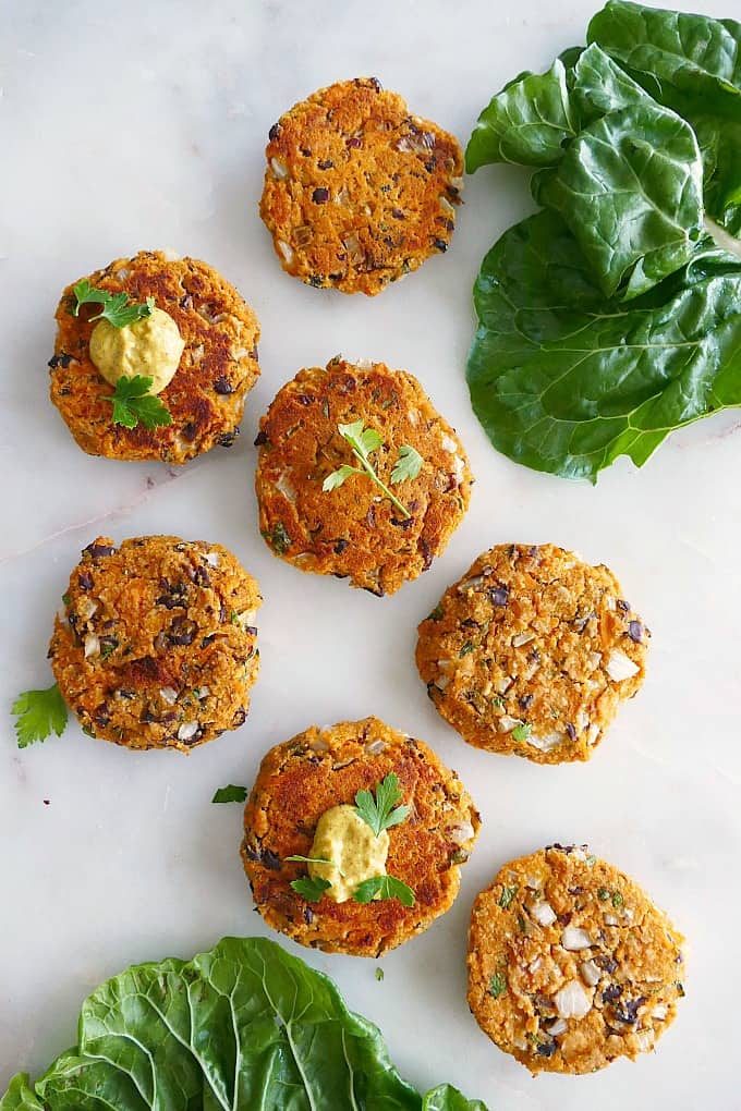 seven sweet potato and black bean burgers spread out next to each other on a counter