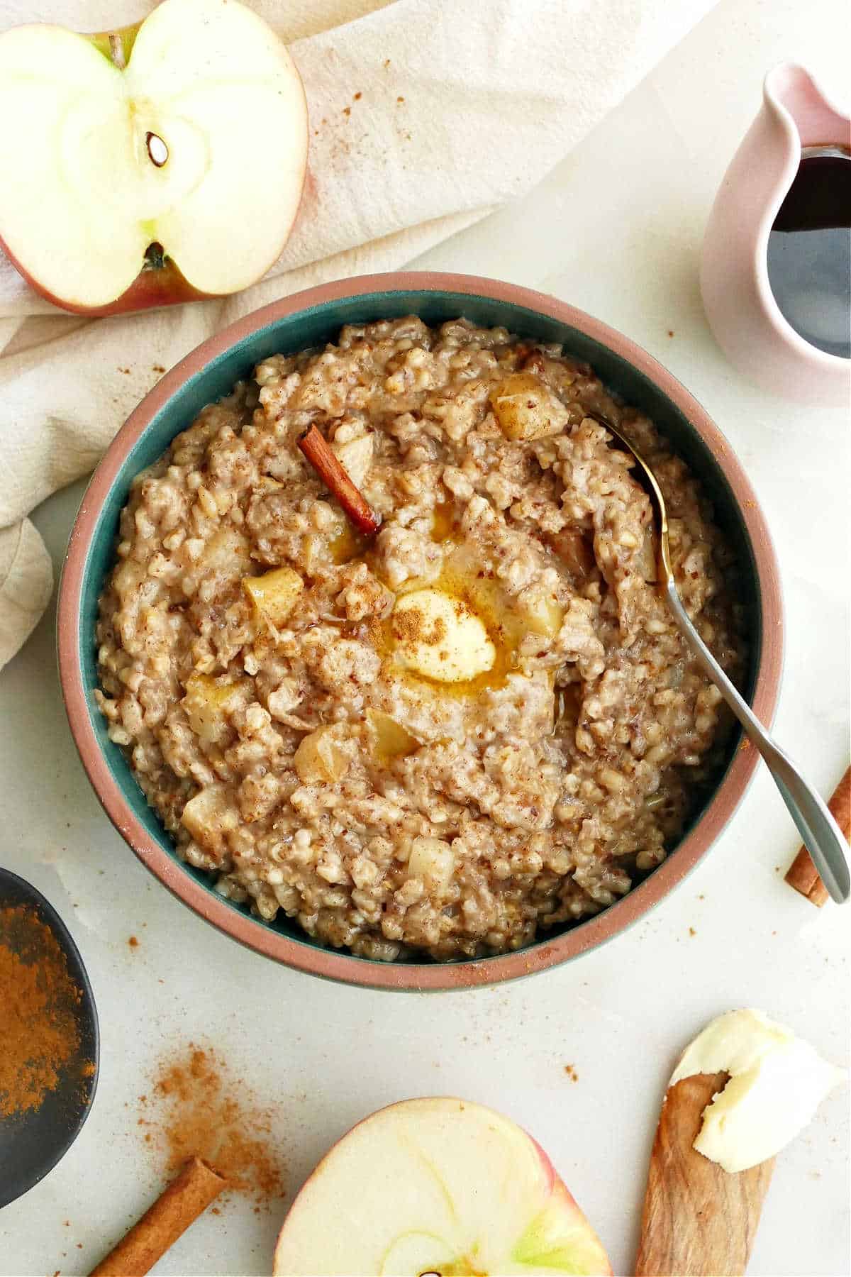 crock pot apple cinnamon oatmeal in a bowl with a spoon on a counter