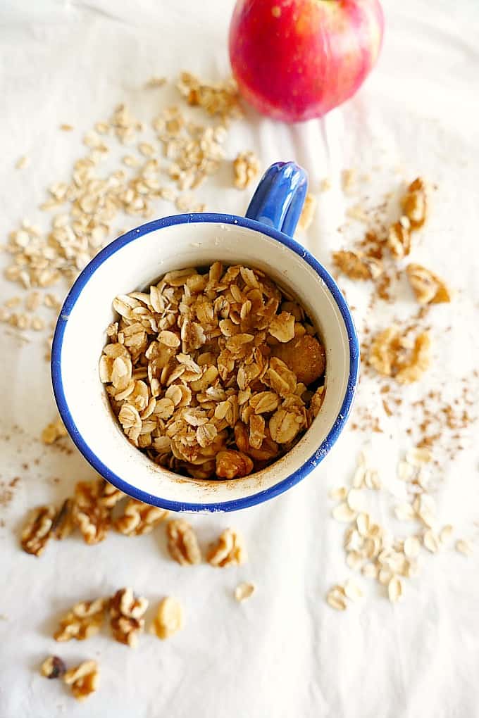 single serve microwave apple crisp in a blue rimmed mug on a tablecloth