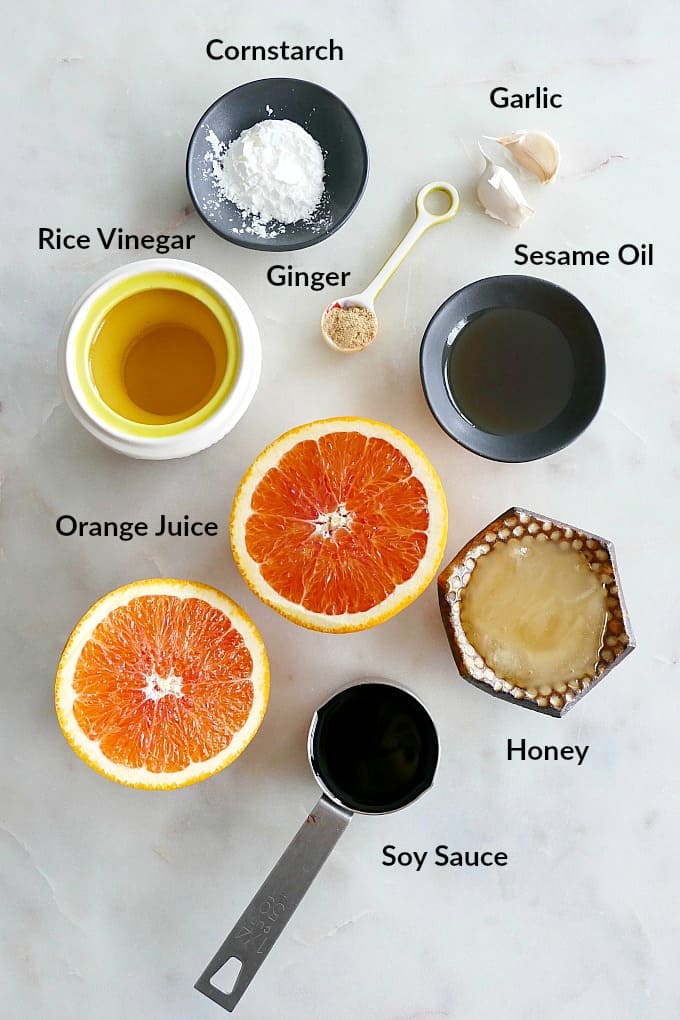 ingredients for orange sesame sauce with text overlay on a white counter