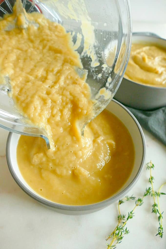 roasted parsnip and pear blender soup being poured from a blender into a soup bowl