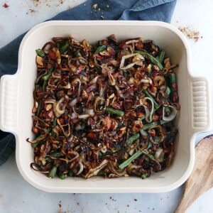 green bean casserole made with maple almonds and crispy shallots in a square baking dish