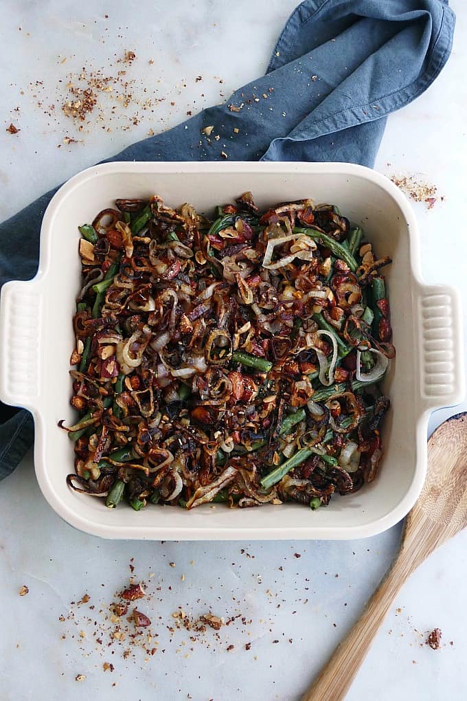 green bean casserole made with maple almonds and crispy shallots in a square baking dish