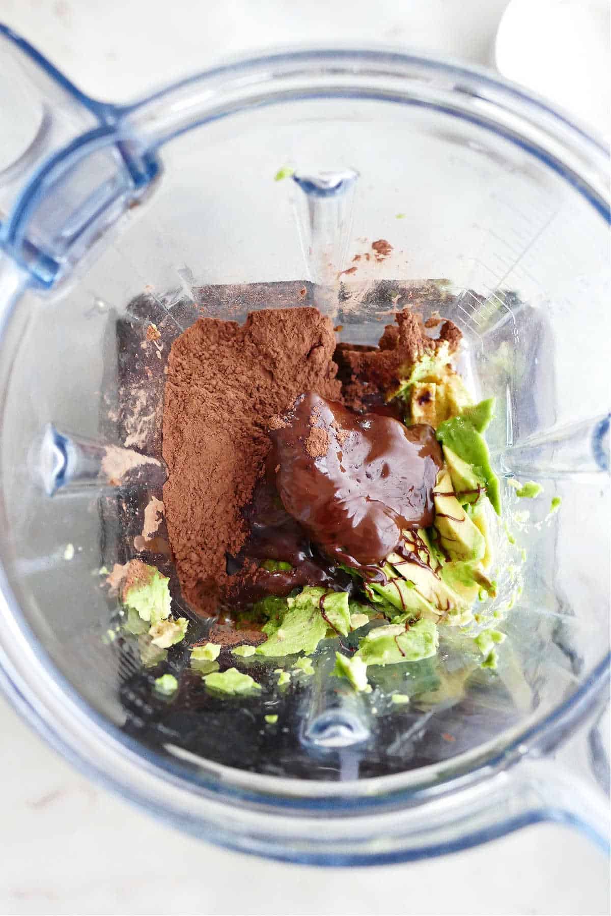 Ingredients for avocado chocolate mousse in blender before blending together
