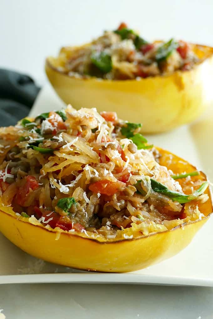 side close-up of a stuffed italian spaghetti squash boat on a white tray