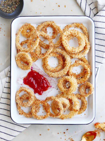 oven baked panko onion rings with ketchup on a tray on a napkin