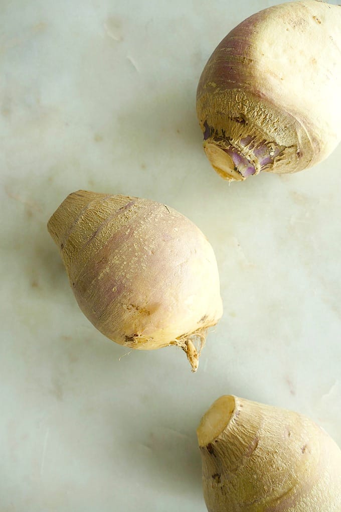 three rutabaga spread out next to each other on a white counter