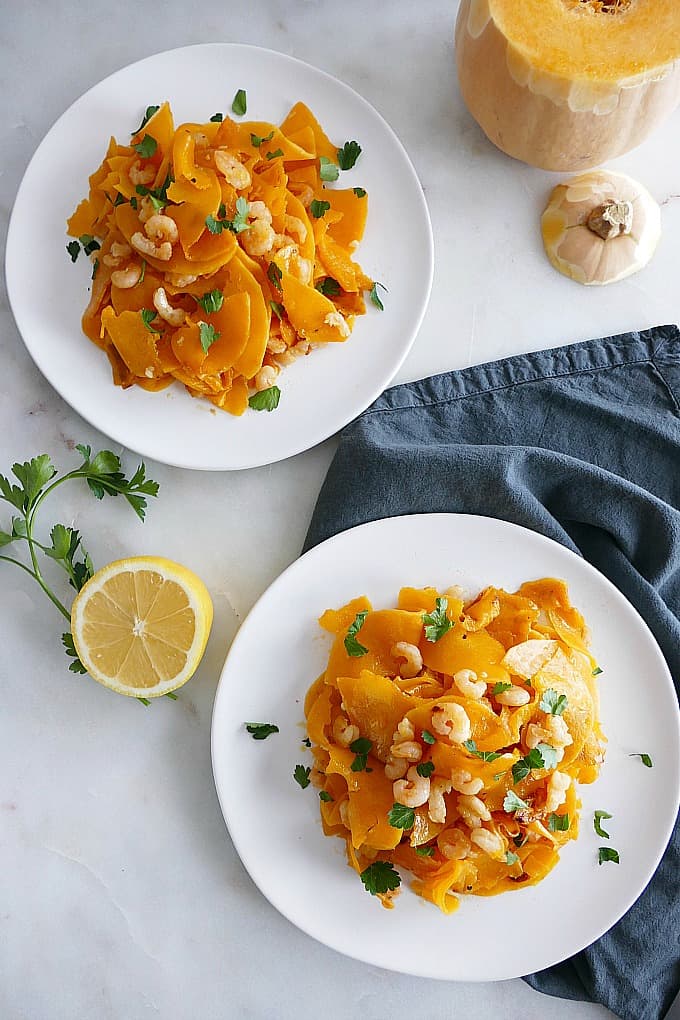 Garlic Lemon Butternut Squash Noodles and Shrimp on white plates a white marble countertop