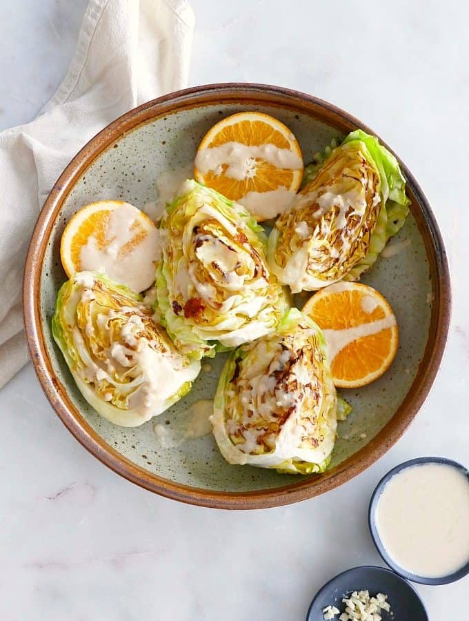 cabbage wedges with orange tahini dressing in a bowl