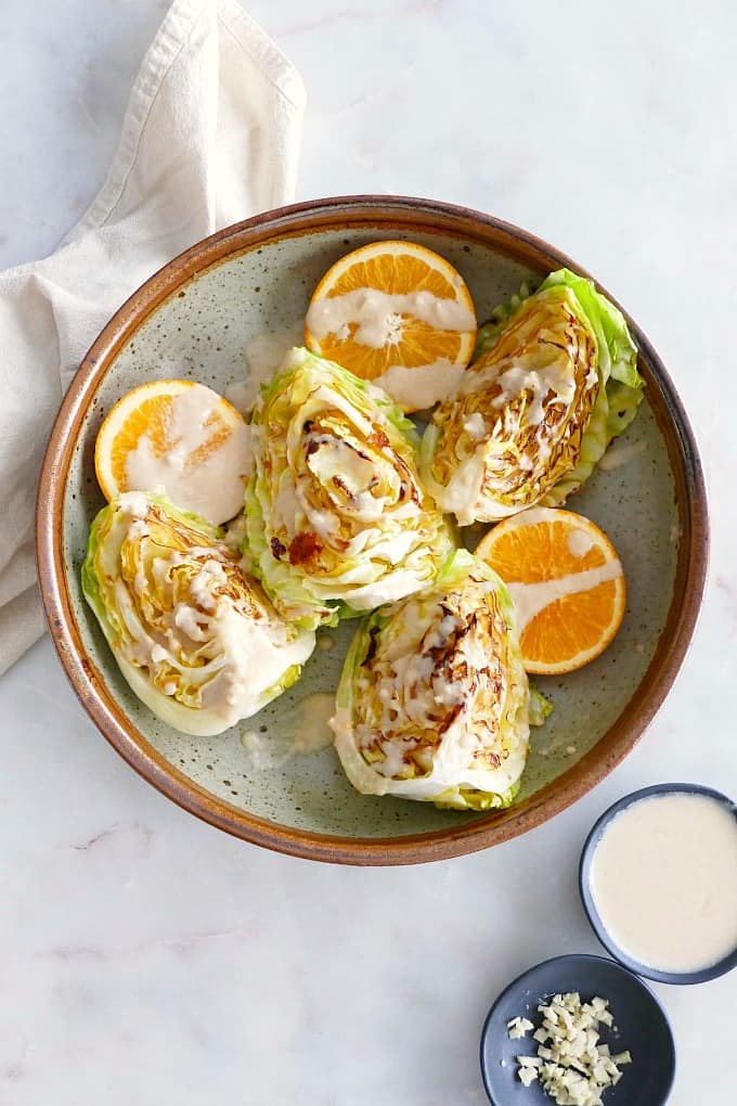 cabbage wedges with orange tahini dressing in a bowl
