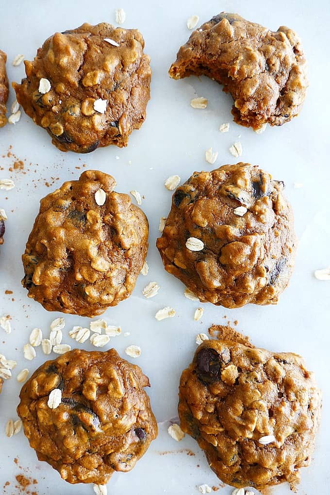 6 gluten free sweet potato cookies on a white countertop with oats sprinkled around