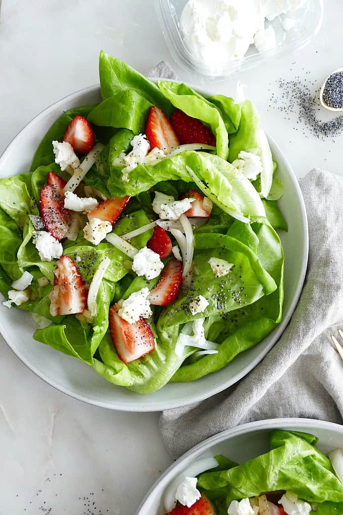Butter Lettuce Strawberry Salad on a white plate on top of a gray napkin
