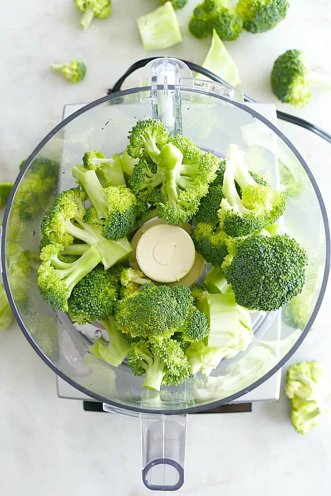 broccoli florets in a cusinart food processor on a white countertop