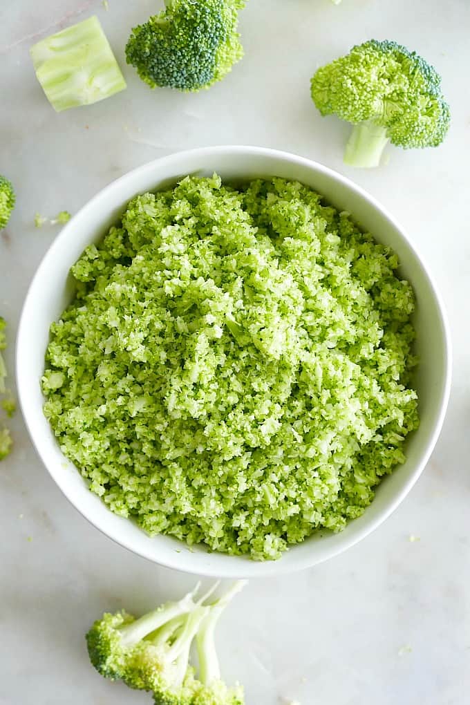 riced broccoli in a white serving bowl on top of a counter