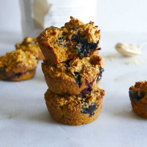 Three oatmeal sweet potato muffins stacked on top of each other.