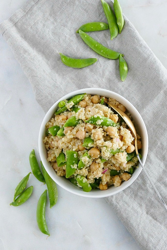 bowl of sugar snap pea quinoa salad on a napkin next to snap peas