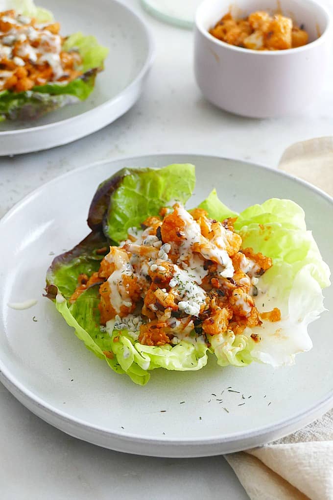 buffalo cauliflower lettuce cups on a serving plate on a counter