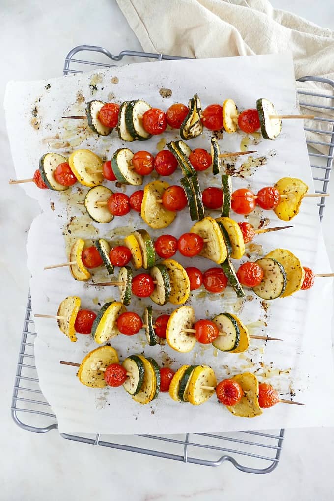 7 veggie kabobs on bamboo skewers on top of parchment lined cooling rack