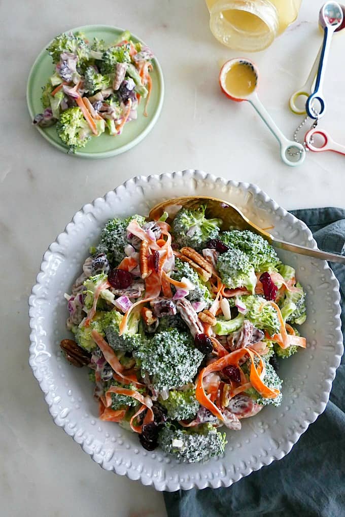 bowl of greek yogurt broccoli salad on a counter next to ingredients