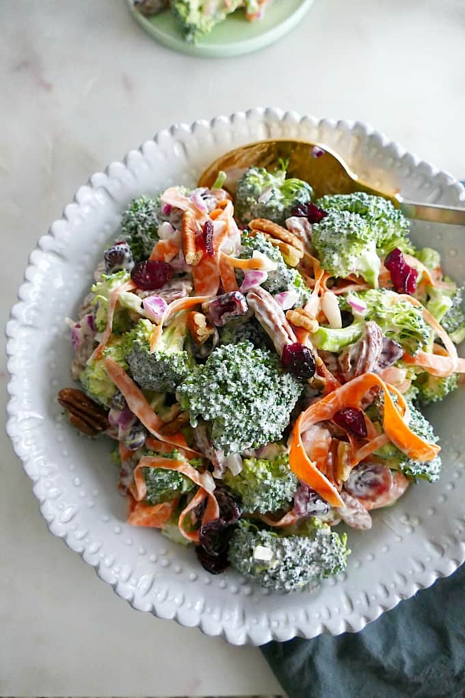 close-up photo of greek yogurt broccoli salad in a white bowl with a spoon