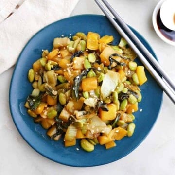 bok choy mango stir fry on a serving plate with chopsticks on the edge