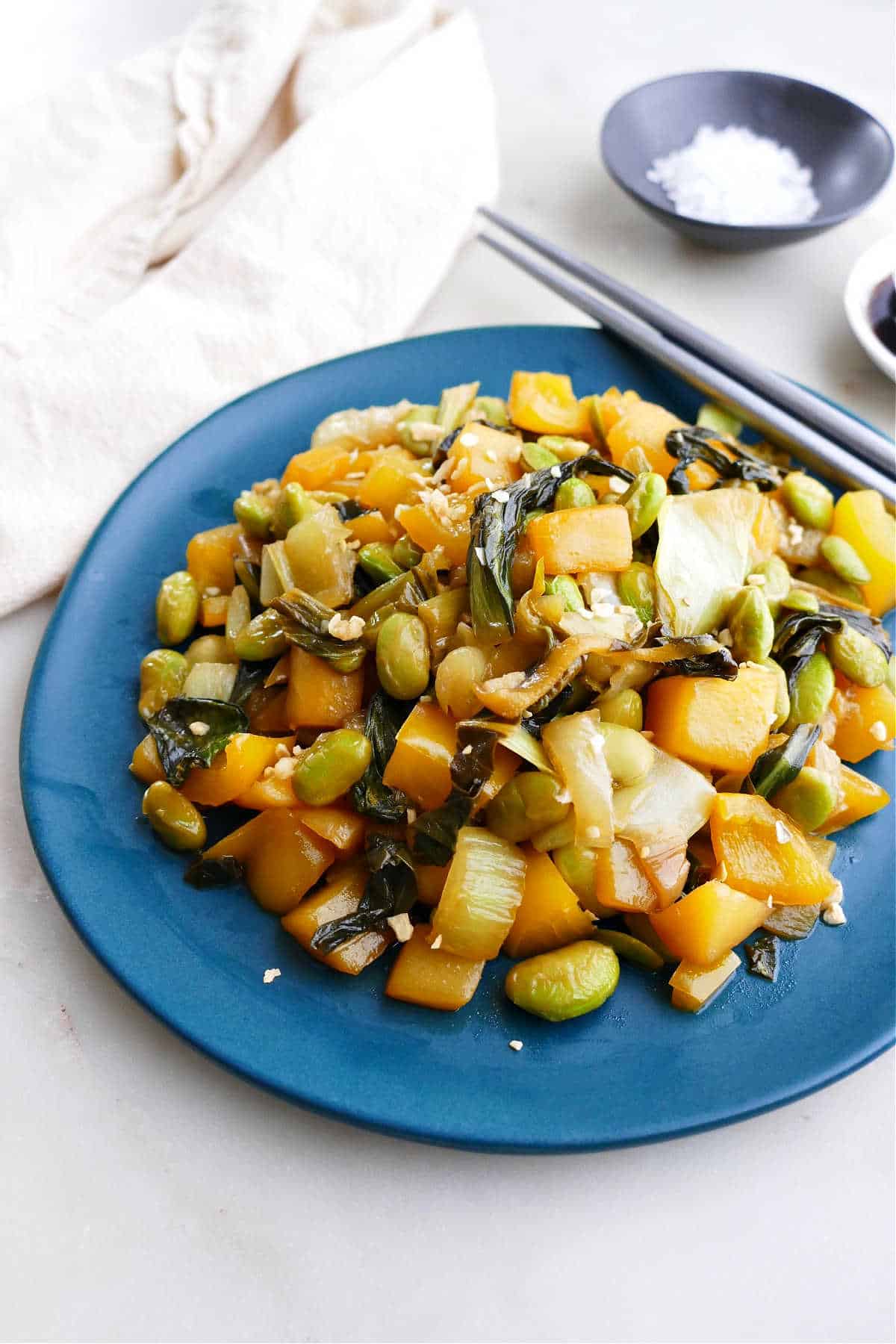 side angle of bok choy stir fry on a serving plate on a counter