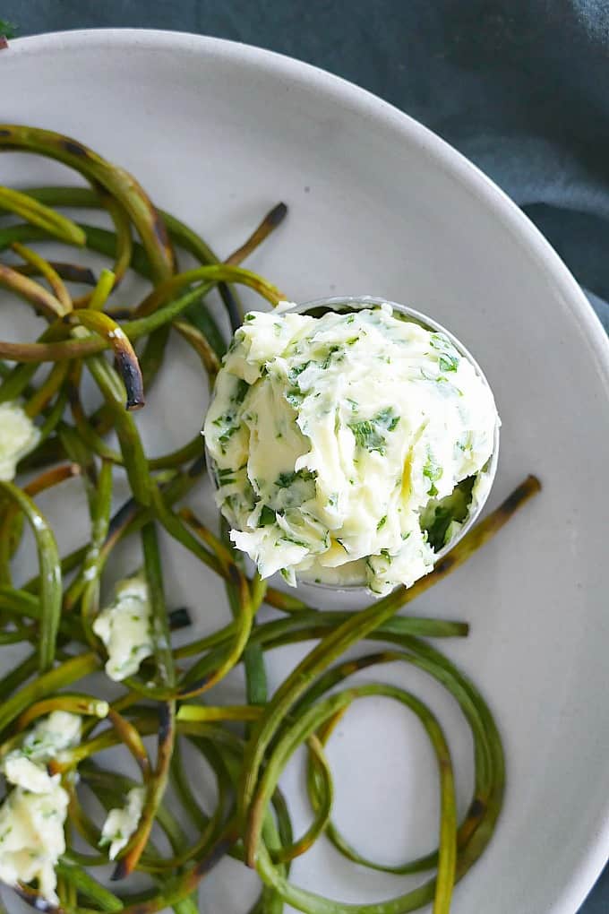 close up of homemade parsley butter in a small container on a plate