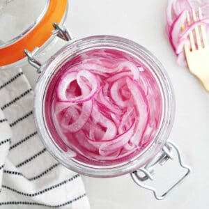 overhead view of pickled red onions in a jar on a counter