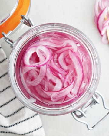 overhead view of pickled red onions in a jar on a counter