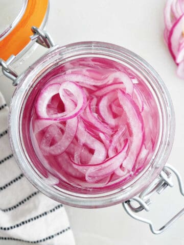 overhead view of pickled red onions in a jar on a counter