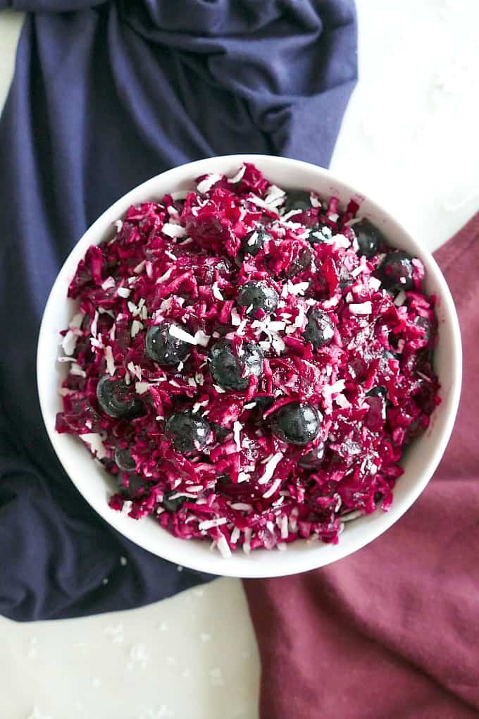 overhead shot of red white blue beet slaw in a white bowl on a counter