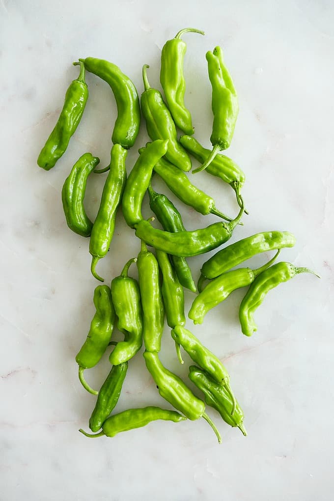 shishito peppers spread out next to each other on top of a counter