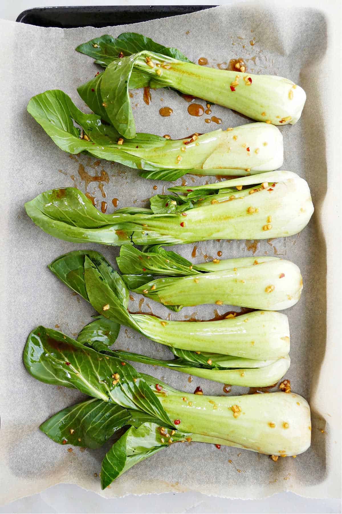 sesame ginger bok choy on lined baking sheet before roasting