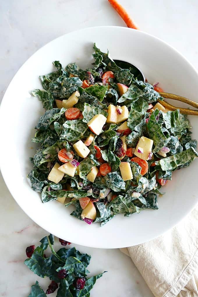 Chopped Kale Salad with Tahini Dressing in a white serving bowl with a spoon