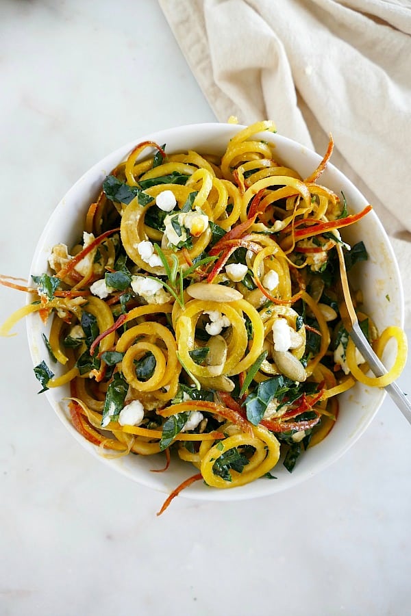 Spiralized Golden Beet Salad with Rosemary Honey Dressing in a white bowl on a counter