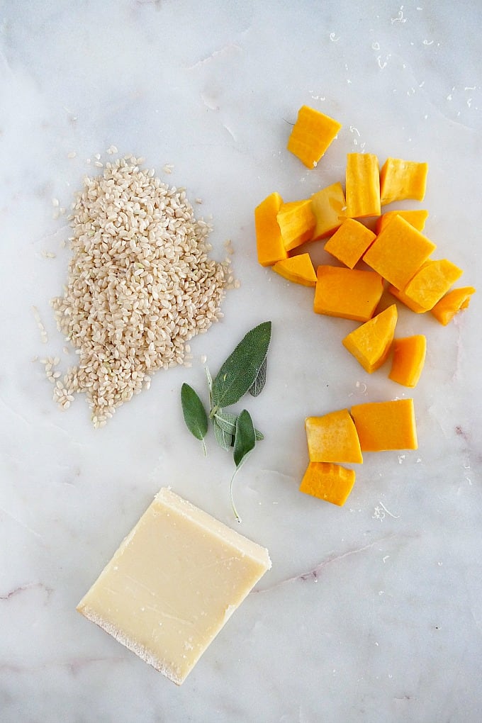 brown rice, butternut squash, sage, and parmesan on a white countertop
