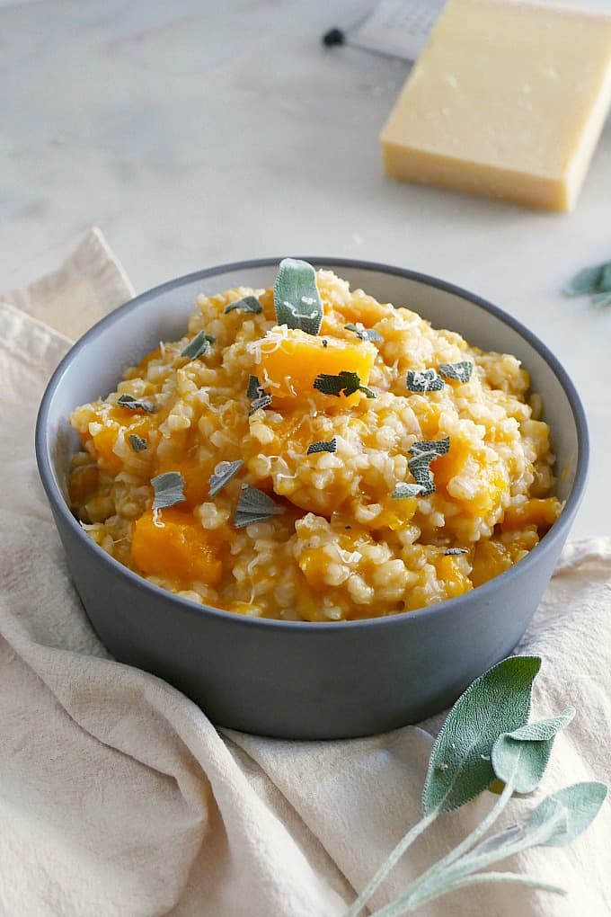 Slow Cooker Brown Rice Butternut Squash Risotto in a gray bowl on a yellow napkin