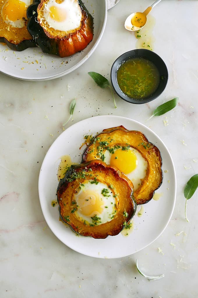 Acorn Squash Eggs with sage brown butter on serving plates on a counter