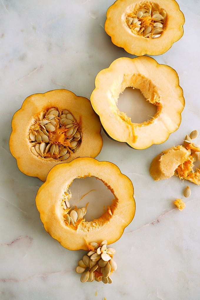 acorn squash sliced into four rings on a counter