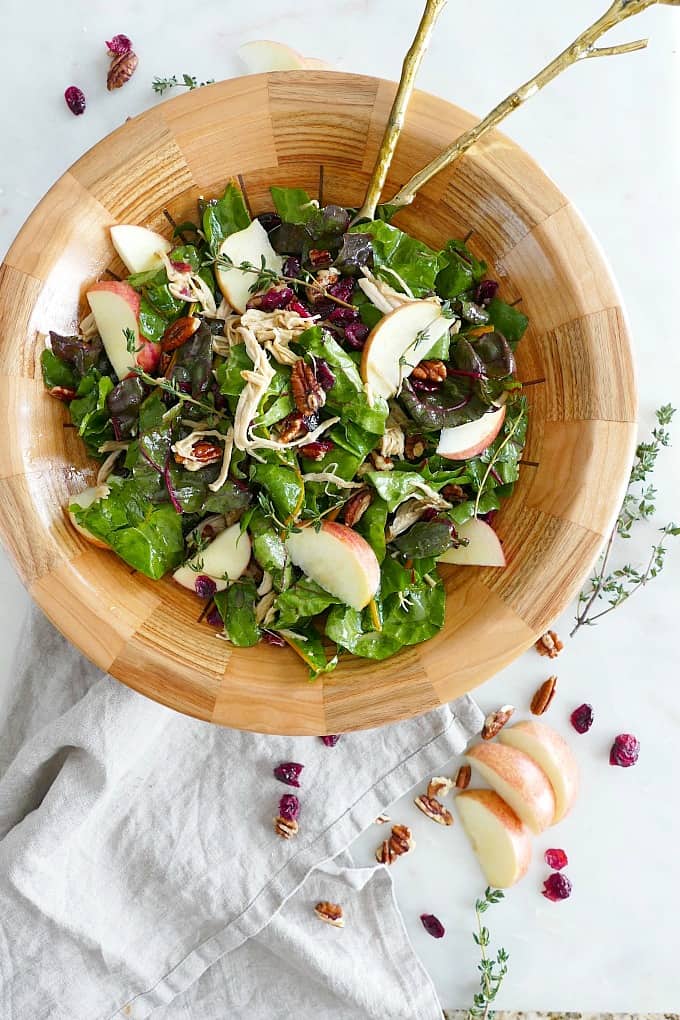 maple swiss chard salad in a large wooden bowl on a gray napkin