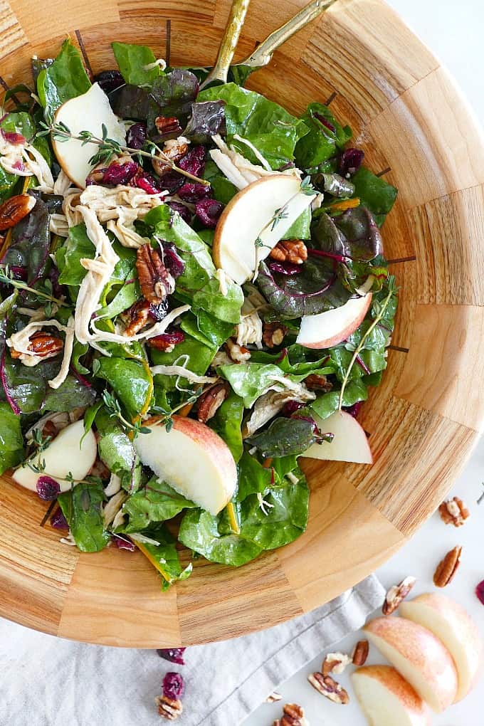 close-up of maple swiss chard salad in a wooden bowl on top of a counterop