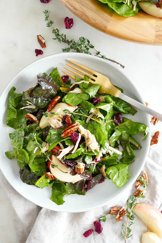 Swiss Chard Salad on a white plate with a gold fork on top of a gray napkin