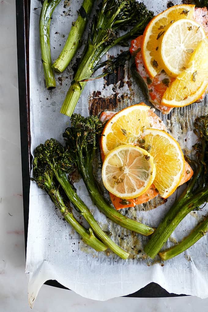 cooked Orange Glazed Salmon and Broccolini on a baking sheet lined with parchment
