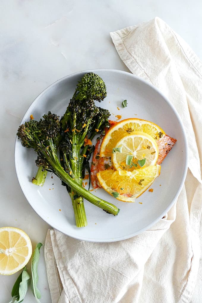 Orange Glazed Salmon and Broccolini on a white plate on top of a napkin