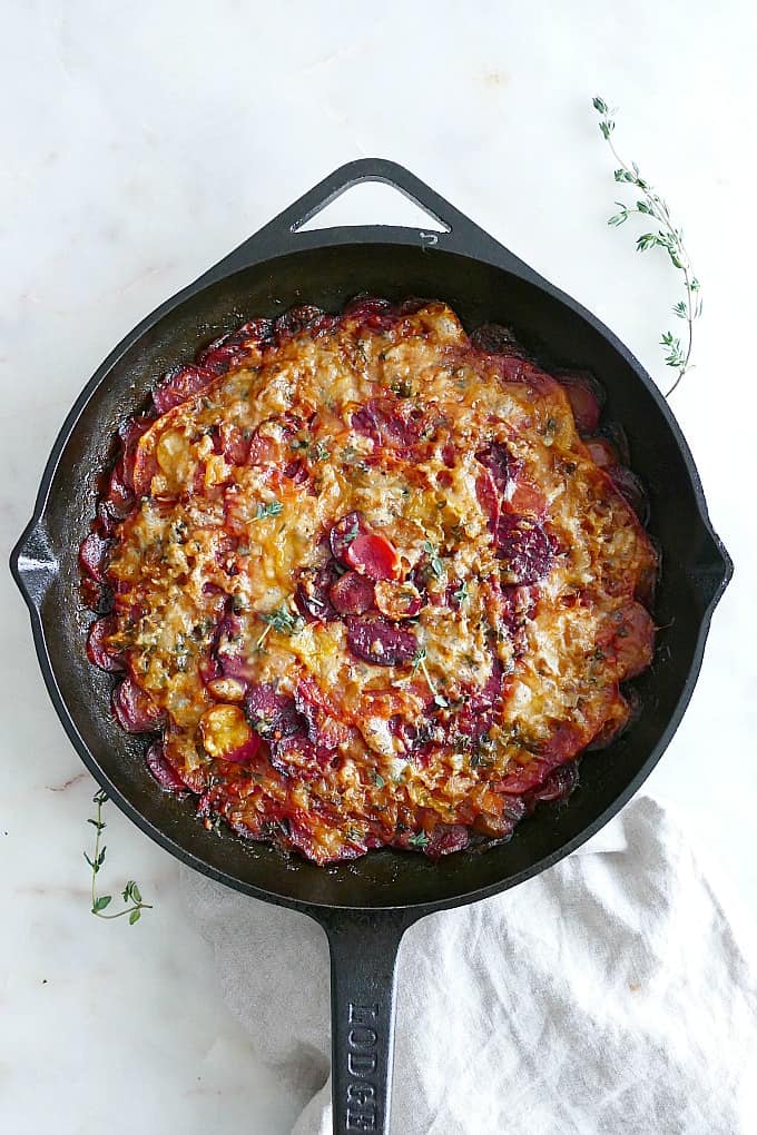 Turnip and Beet Gratin in a black cast iron skillet on a white countertop