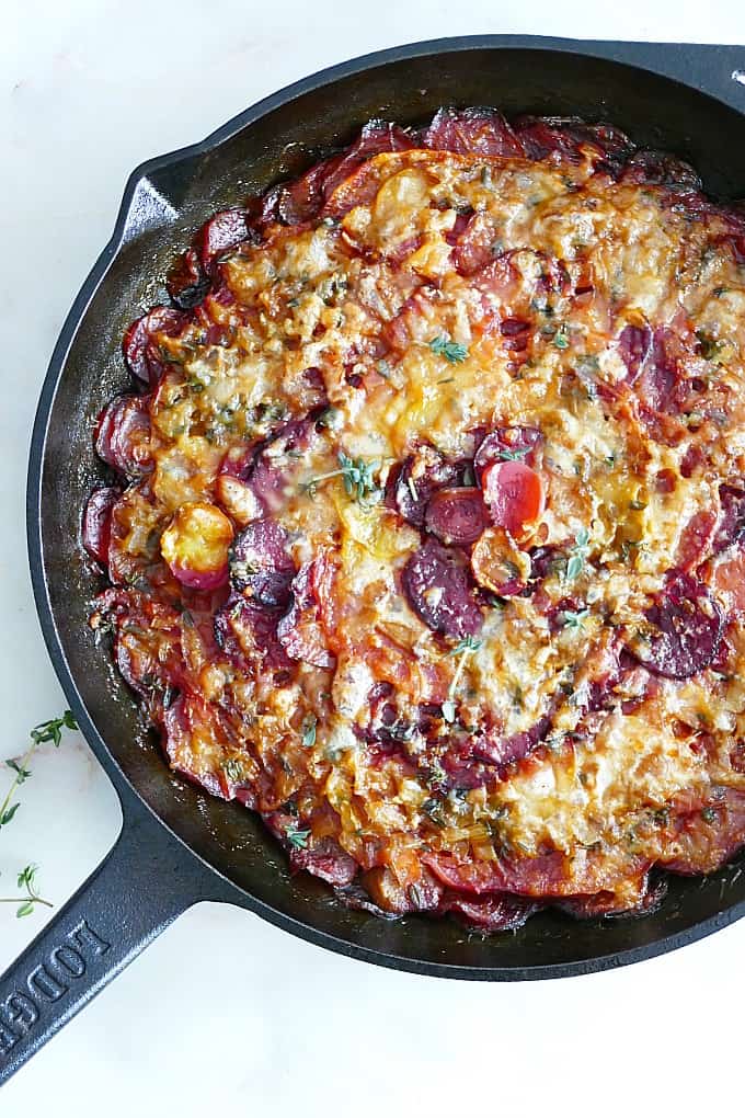 close up of turnip and beet gratin with gruyere in a cast iron skillet